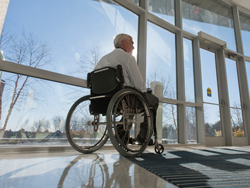 Image of a man in a wheelchair in a building foyer